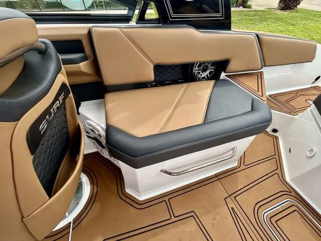 Slide: The Image of 2023 Cobalt R6 Surf boat interior with tan and black seating, featuring stylish design and speaker. - 45