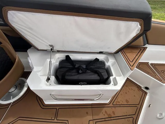 Slide: The Image of 2023 Cobalt R6 Surf boat storage compartment with black bag inside. - 48