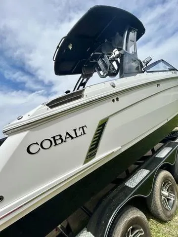 Slide: The Image of 2023 Cobalt R6 Surf boat on trailer, under a partly cloudy sky. - 9