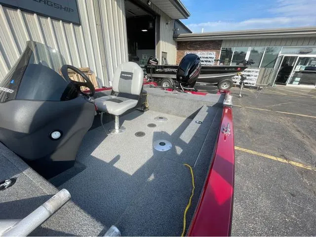 Slide: The Image of 2019 Tracker Super Guide™ V-16 SC boat interior with steering console and seating, parked outside dealership. - 11