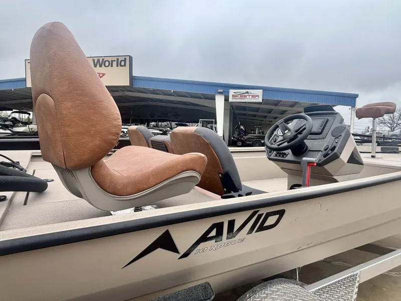 Slide: The Image of 2025 Avid 18 Rogue SC boat interior with brown seats and steering console. - 2