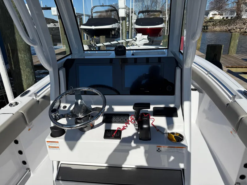 Slide: The Image of 2024 Sportsman Heritage 231 Center Console boat dashboard with steering wheel and controls. - 11