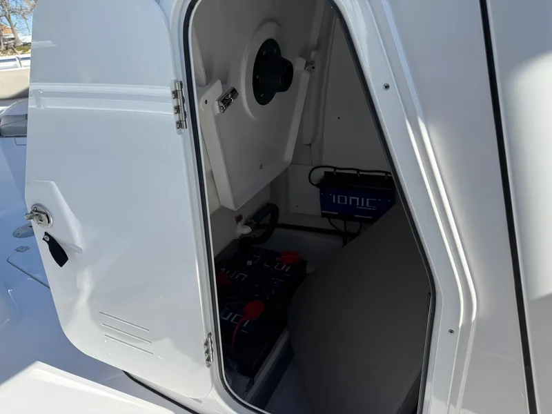 Slide: The Image of 2024 Sportsman Heritage 231 Center Console storage compartment with Ionic batteries visible. - 16