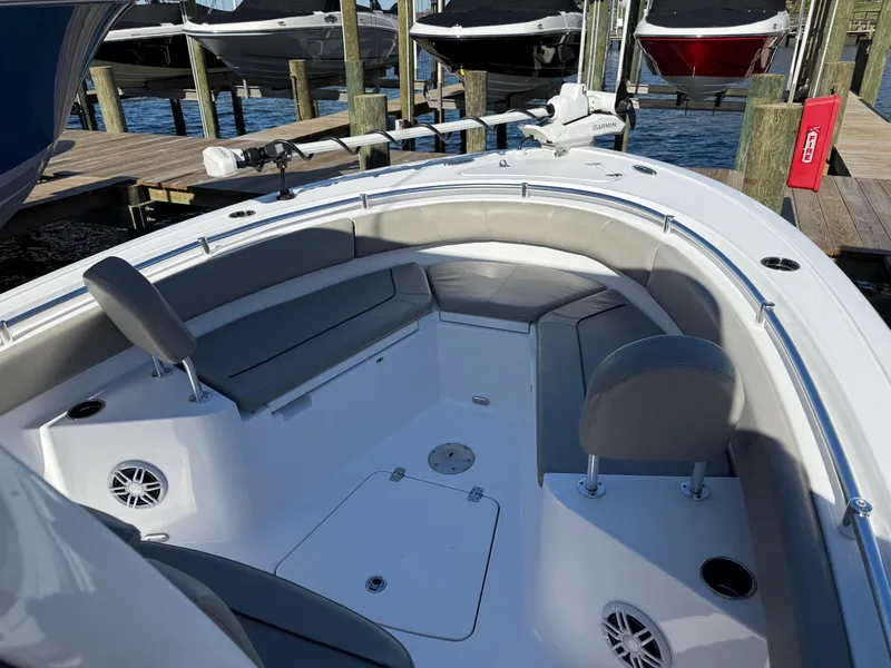 Slide: The Image of 2024 Sportsman Heritage 231 Center Console boat interior with seating and speakers at a dock. - 19