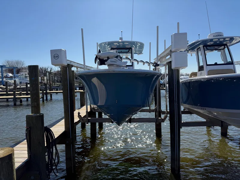 Slide: The Image of 2024 Sportsman Heritage 231 Center Console boat docked at marina. - 2