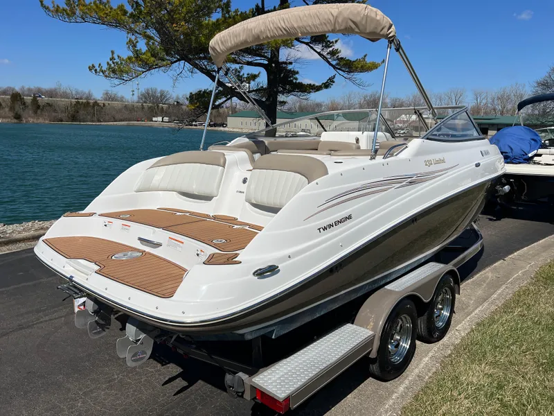 Slide: The Image of 2008 Yamaha Boats 232 Limited on trailer by a lake, featuring sleek design and twin engines. - 4