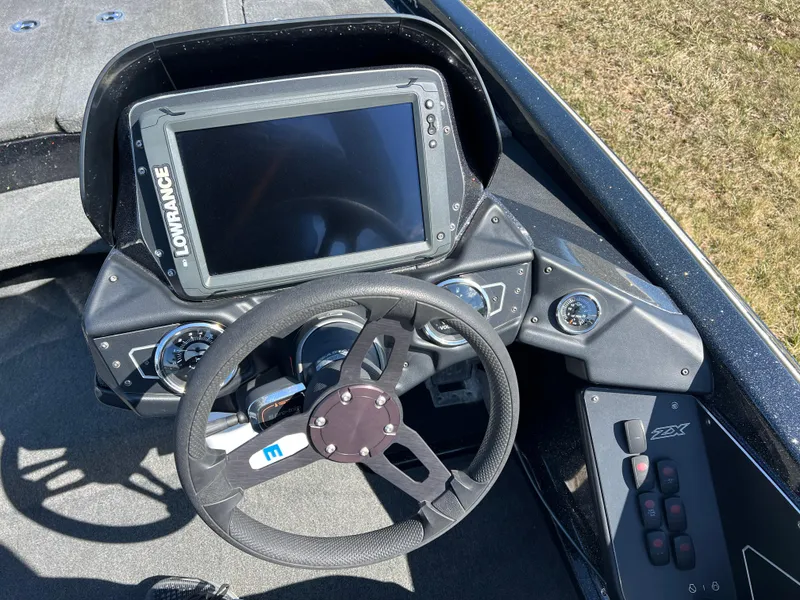 Slide: The Image of 2018 Skeeter ZX 225 boat dashboard with Lowrance display and steering wheel. - 14