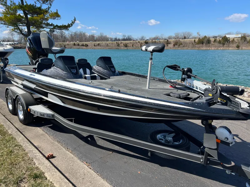 Slide: The Image of 2018 Skeeter ZX 225 bass boat parked by a lake on a sunny day. - 3