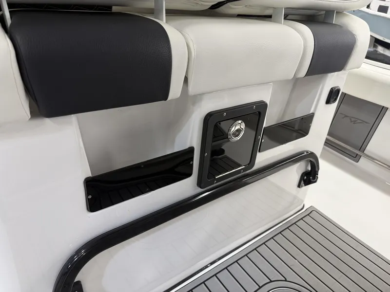 Slide: The Image of 2025 Tidewater 3100 Carolina Bay boat interior with cushioned seating and storage compartment. - 10