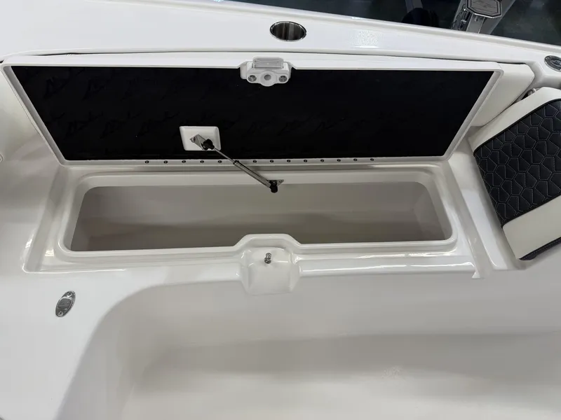 Slide: The Image of 2025 Tidewater 3100 Carolina Bay boat storage compartment with open lid and cushioned seating. - 16
