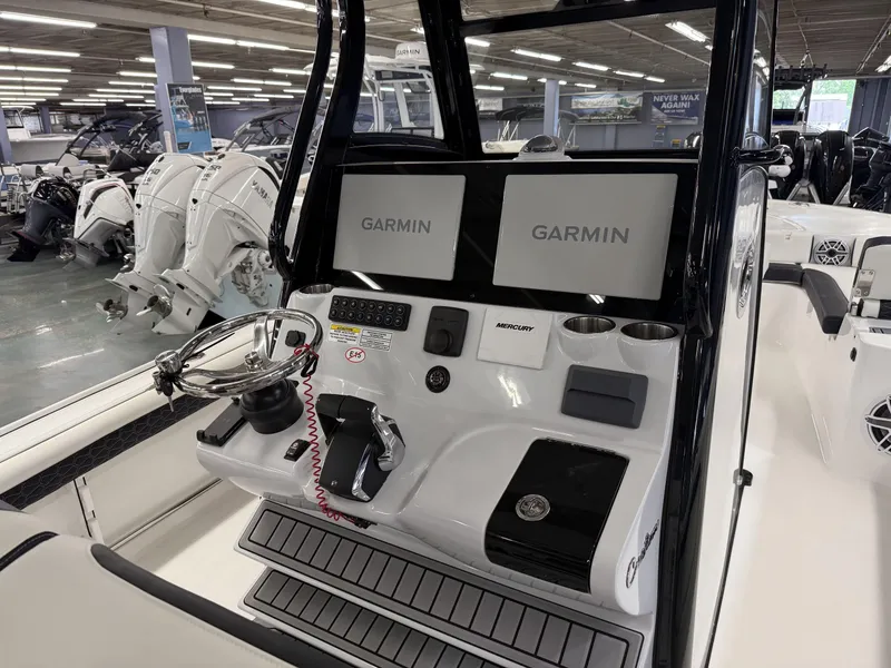 Slide: The Image of 2025 Tidewater 3100 Carolina Bay boat console with dual Garmin displays and Mercury controls. - 25