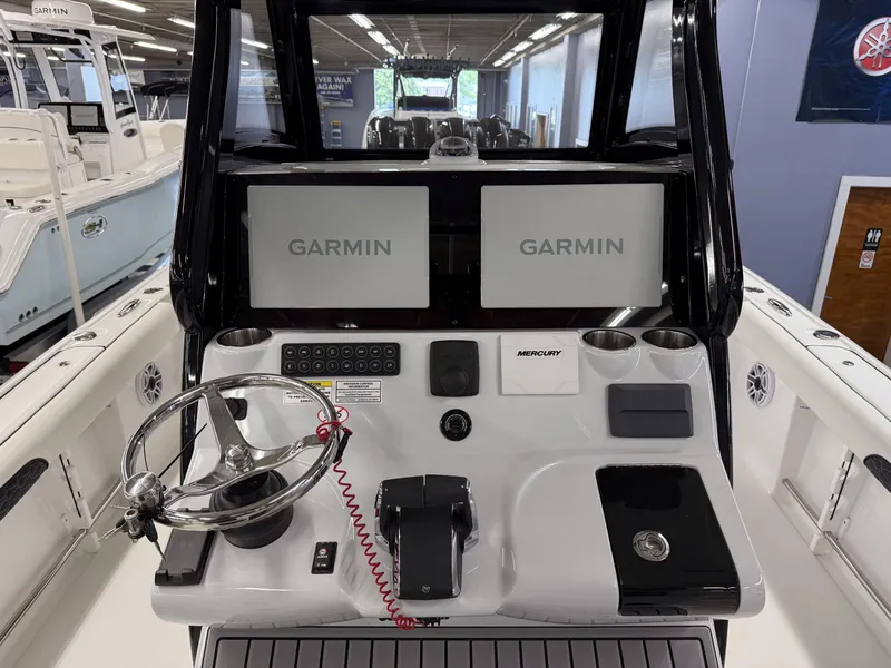 Slide: The Image of 2025 Tidewater 3100 Carolina Bay boat console with dual Garmin displays and Mercury controls. - 26