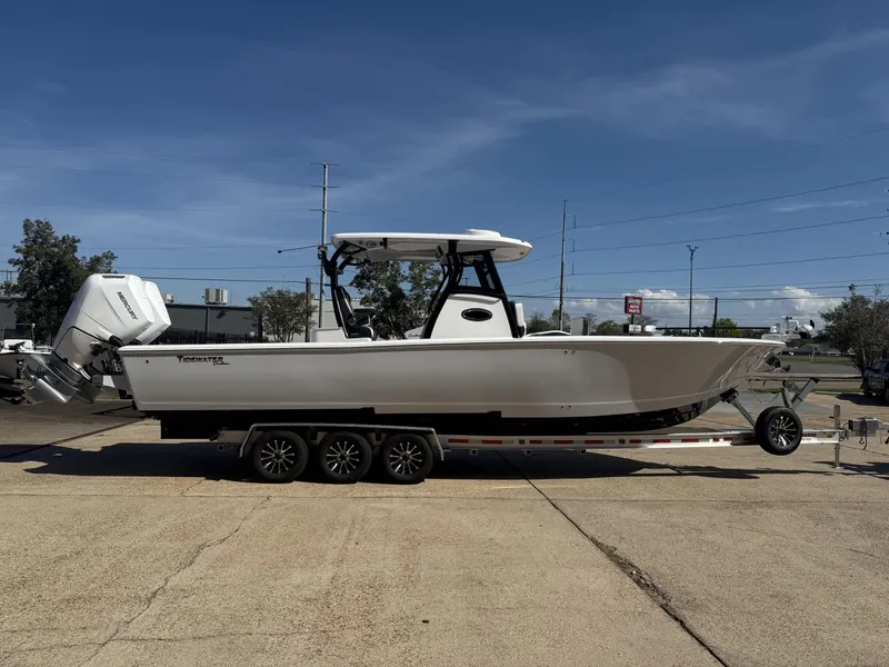 Slide: The Image of 2025 Tidewater 3100 Carolina Bay boat on trailer, parked outdoors under clear sky. - 3