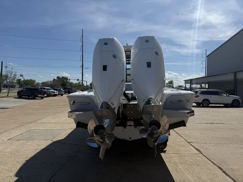 Slide: The Image of 2025 Tidewater 3100 Carolina Bay boat with dual outboard engines, parked outdoors. - 5
