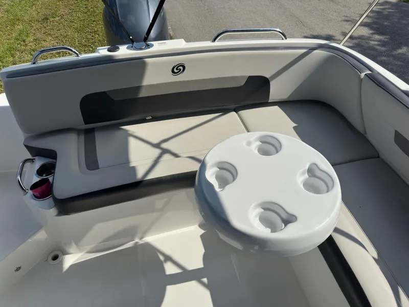Slide: The Image of 2022 Hurricane SunDeck 235 OB boat interior with seating and cup holders. - 11