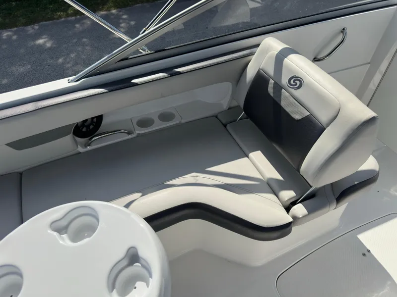 Slide: The Image of 2022 Hurricane SunDeck 235 OB boat interior with cushioned seating and cup holders. - 12