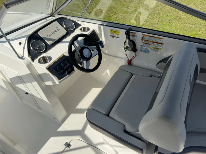 Slide: The Image of 2022 Hurricane SunDeck 235 OB boat interior with steering wheel and Garmin display. - 14