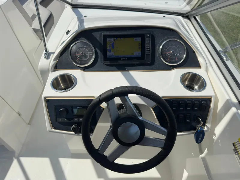 Slide: The Image of 2022 Hurricane SunDeck 235 OB dashboard with steering wheel and navigation display. - 15