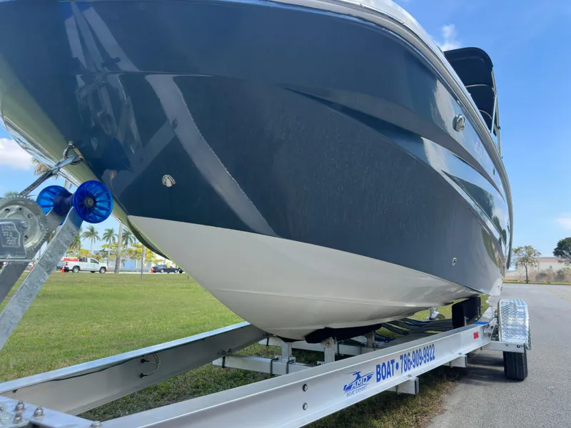 Slide: The Image of 2022 Hurricane SunDeck 235 OB boat on trailer, side view, outdoors. - 8