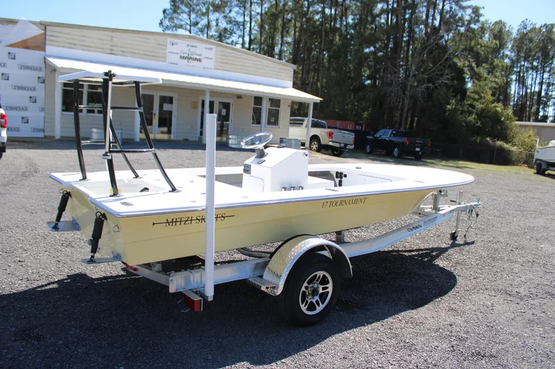 Slide: The Image of 2025 Mitzi Skiffs 17 Tournament boat on trailer, parked outdoors near a building. - 18