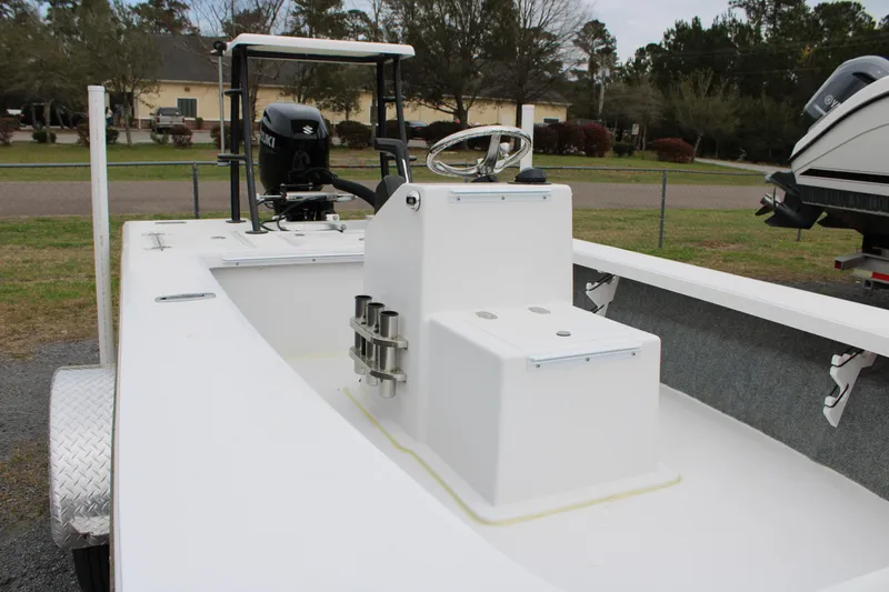 Slide: The Image of 2025 Mitzi Skiffs 17 Tournament boat with center console and outboard motor, parked outdoors. - 25