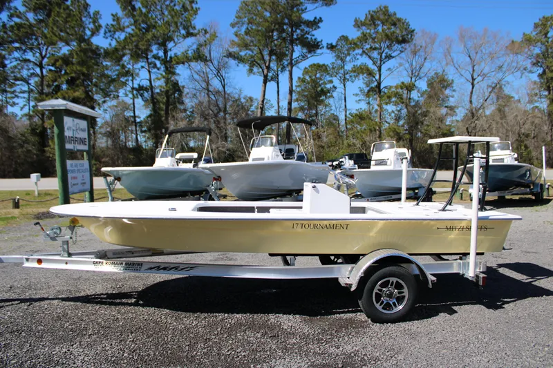Slide: The Image of 2025 Mitzi Skiffs 17 Tournament boat on trailer, parked outdoors with trees in background. - 8