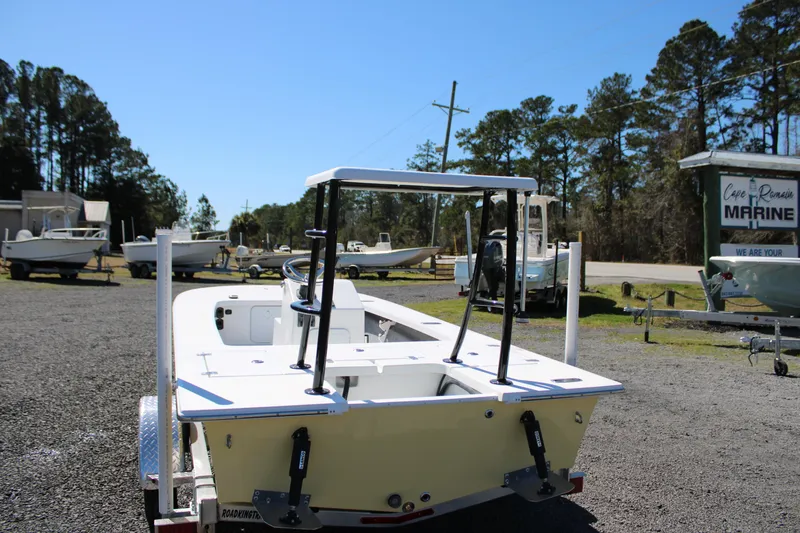 Slide: The Image of 2025 Mitzi Skiffs 17 Tournament boat on trailer in marina lot, surrounded by trees. - 9