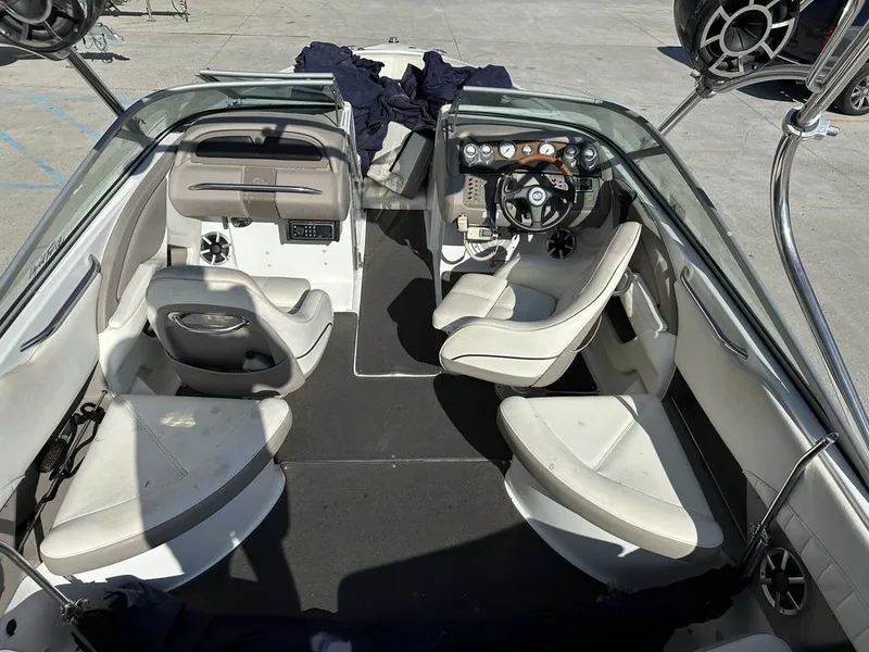 Slide: The Image of Interior of a 2006 Cobalt 250 boat with white seating and steering wheel. - 13