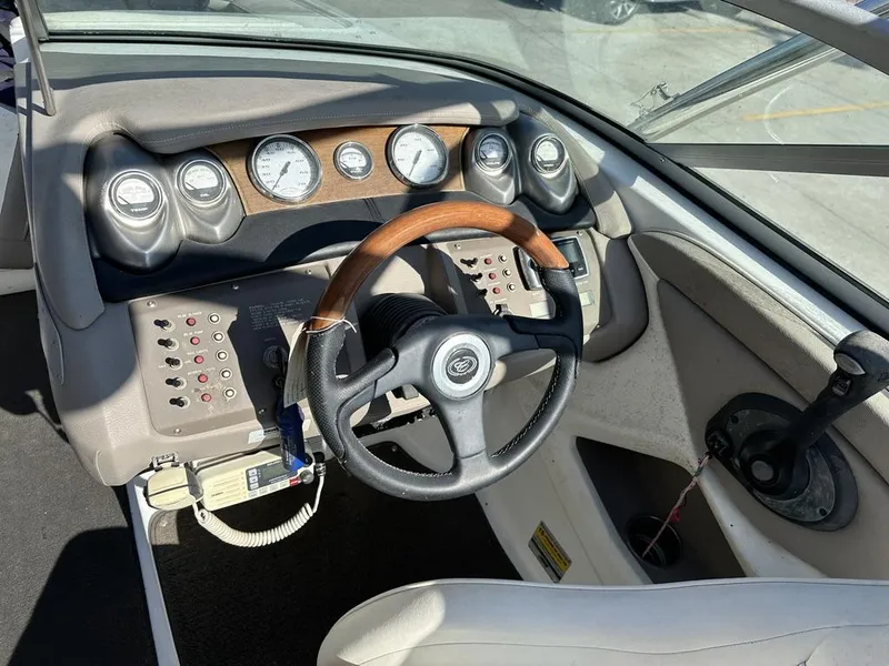 Slide: The Image of 2006 Cobalt 250 boat dashboard with gauges, steering wheel, and control panel. - 14