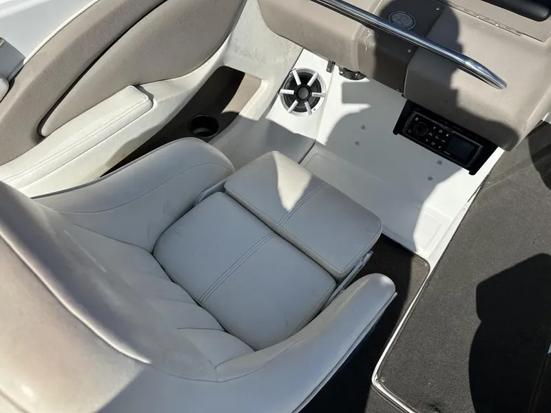 Slide: The Image of 2006 Cobalt 250 boat interior with white seating and audio system. - 15