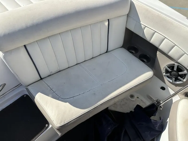 Slide: The Image of White leather seating on a 2006 Cobalt 250 boat, featuring cup holders and speaker. - 2