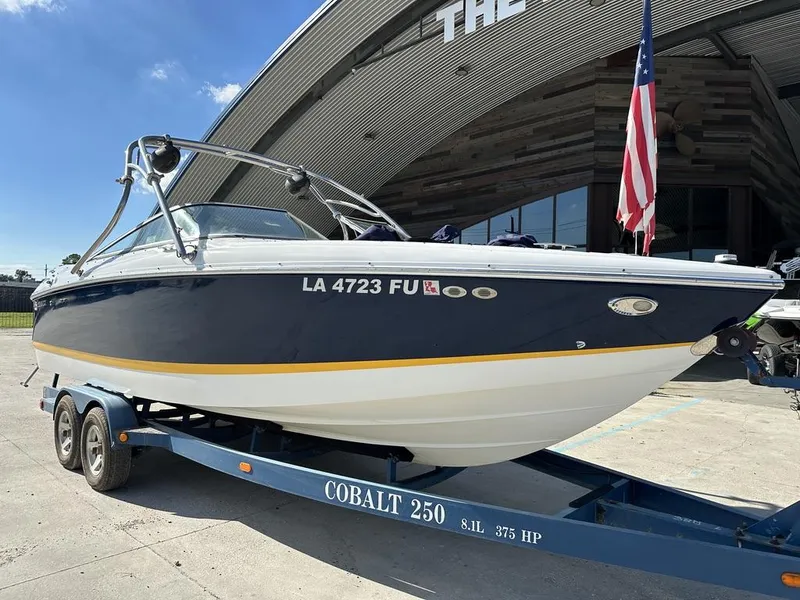 Slide: The Image of 2006 Cobalt 250 boat on trailer, parked outside a building with an American flag. - 5