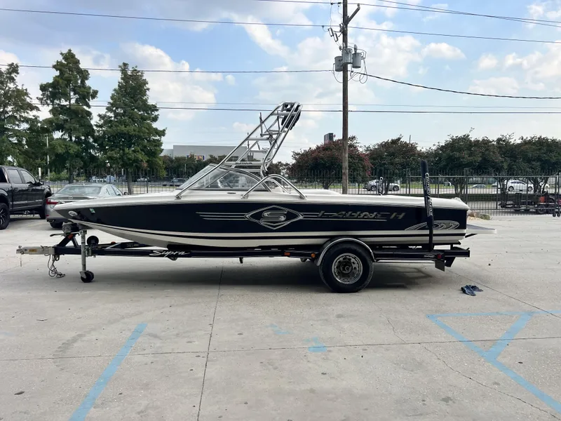 Slide: The Image of 2003 Supra Launch LTS boat on trailer in parking lot, side view. - 10