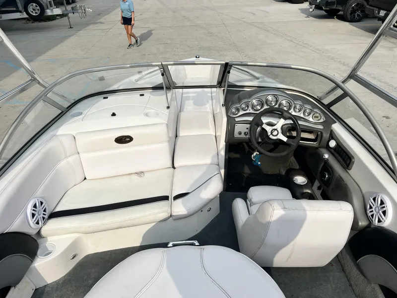 Slide: The Image of 2003 Supra Launch LTS boat interior with white seating and dashboard controls. - 13