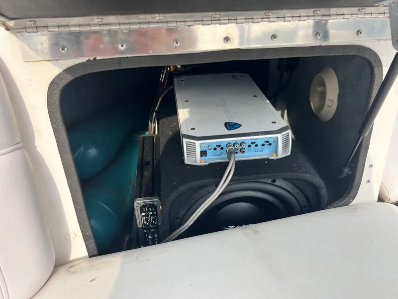 Slide: The Image of 2003 Supra Launch LTS boat audio system with amplifier and subwoofer in storage compartment. - 17