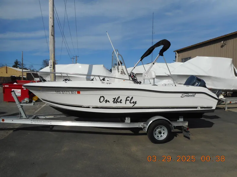 Slide: The Image of 2002 Seaswirl Striper 1851 Center Console boat on trailer, labeled "On the Fly." - 0