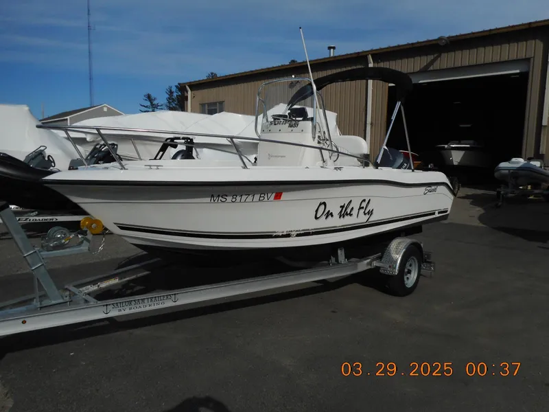 Slide: The Image of 2002 Seaswirl Striper 1851 Center Console boat on trailer, labeled "On The Fly." - 1