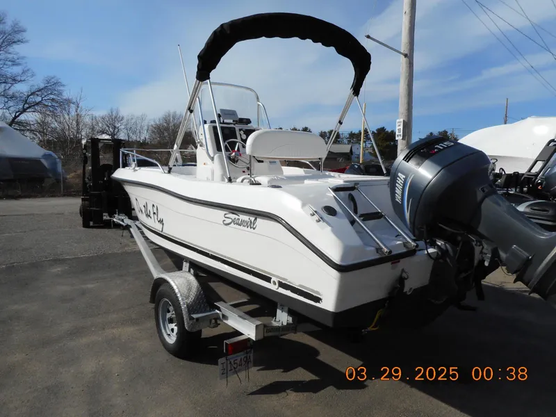 Slide: The Image of 2002 Seaswirl Striper 1851 Center Console boat on trailer, outdoor setting. - 3
