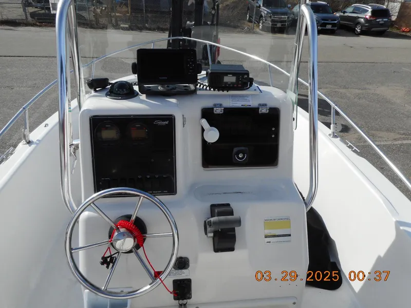 Slide: The Image of 2002 Seaswirl Striper 1851 Center Console boat dashboard with steering wheel and controls. - 7