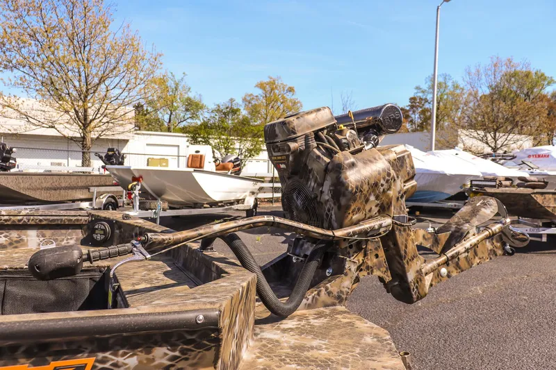 Slide: The Image of 2025 Excel 1751 F4 Shallow Water boat with camo design, parked outdoors. - 13