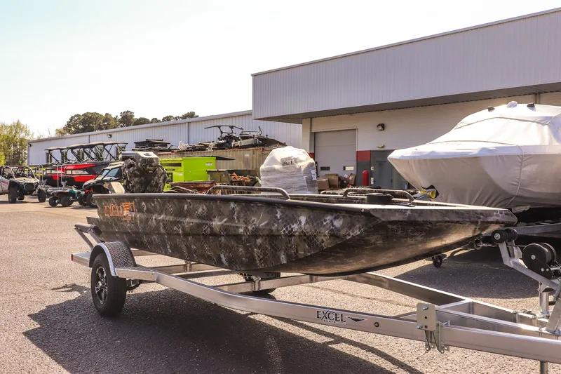 Slide: The Image of 2025 Excel 1751 F4 Shallow Water boat on trailer outside a warehouse. - 3