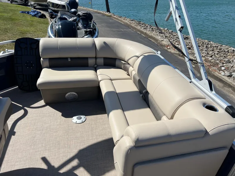 Slide: The Image of 2023 Sun Tracker Party Barge 20 DLX with beige seating, docked by a lake. - 17