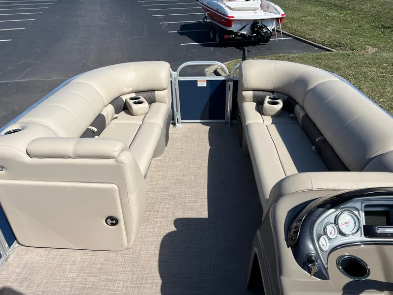 Slide: The Image of 2023 Sun Tracker Party Barge 20 DLX interior with beige seating and control panel. - 22