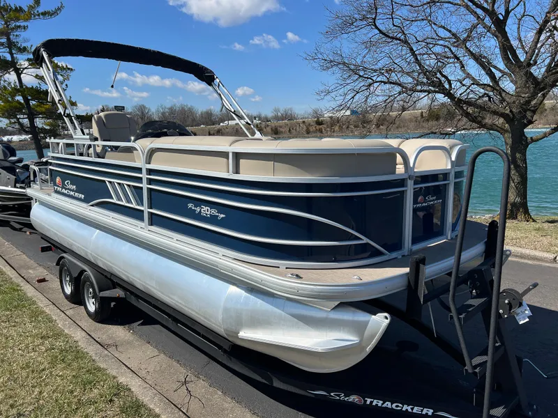 Slide: The Image of 2023 Sun Tracker Party Barge 20 DLX pontoon boat on trailer by a lake. - 3