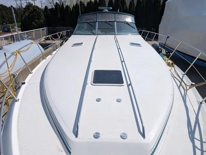 Slide: The Image of 1995 Sea Ray 400 Express Cruiser boat deck, white surface, docked outdoors. - 12