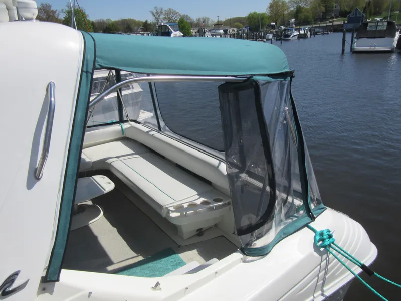 Slide: The Image of 1995 Sea Ray 400 Express Cruiser with teal canopy docked by the water. - 13
