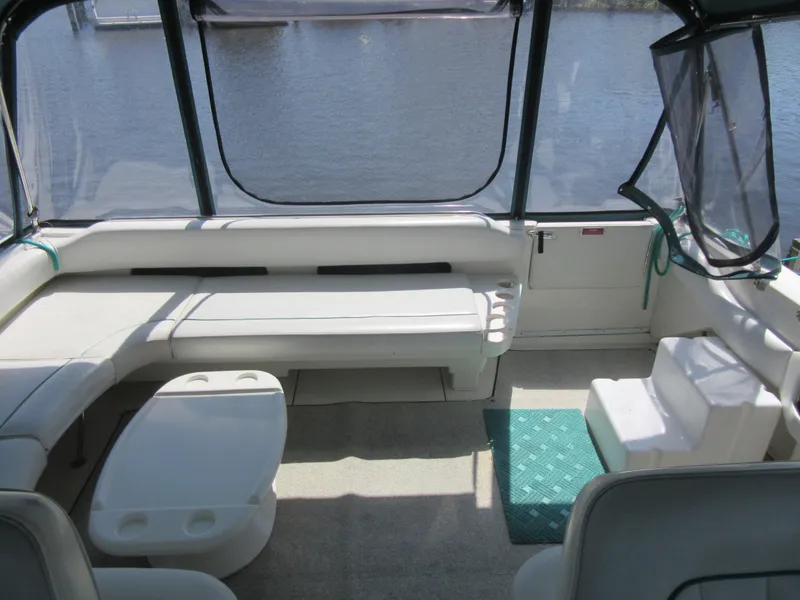 Slide: The Image of 1995 Sea Ray 400 Express Cruiser interior with seating and table, overlooking water. - 14