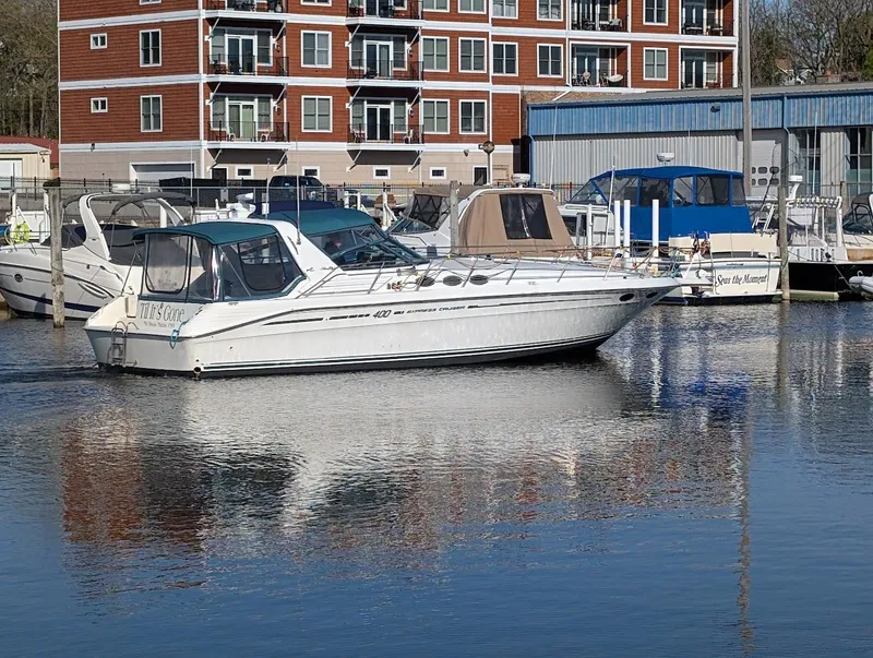 Slide: The Image of 1995 Sea Ray 400 Express Cruiser docked in marina, reflecting on calm water. - 2