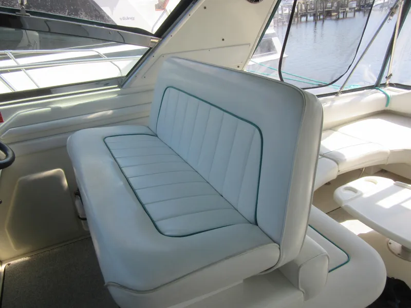 Slide: The Image of 1995 Sea Ray 400 Express Cruiser interior with white seating and marina view. - 20