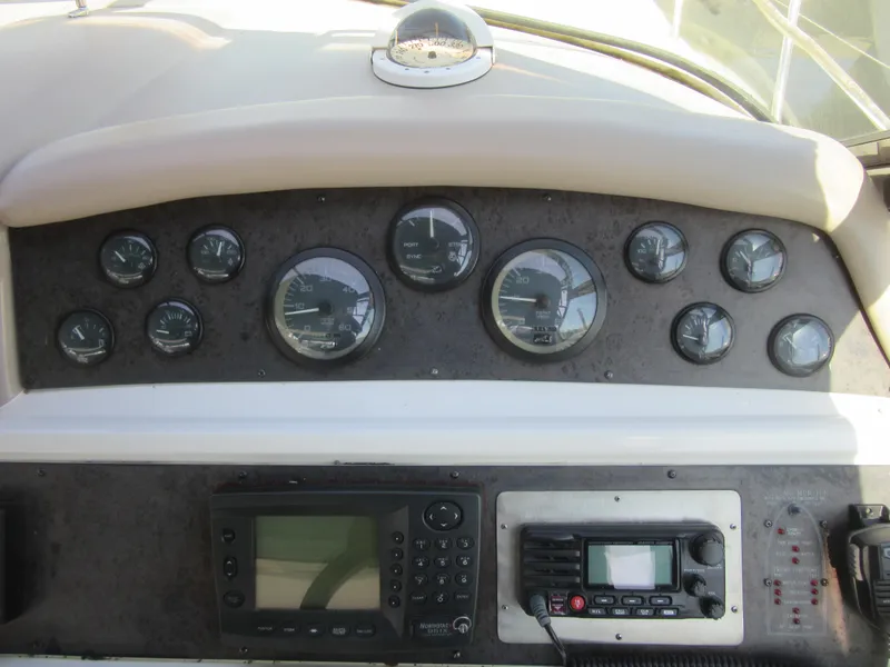 Slide: The Image of Dashboard of a 1995 Sea Ray 400 Express Cruiser with gauges and navigation equipment. - 22
